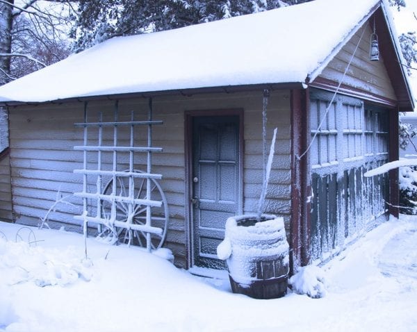 garage with sliding barn doors in snow