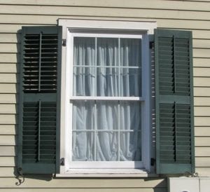 green wood louvered window shutters